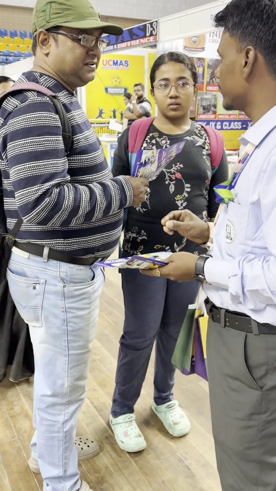 Two visitors looking through printed brochures at the fair.
