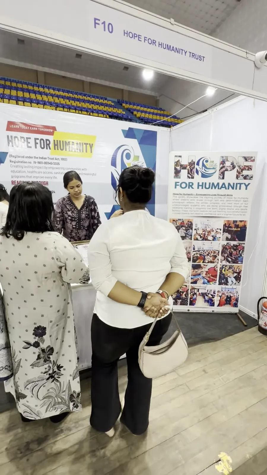 Visitors studying information boards at the back of an exhibition stall.