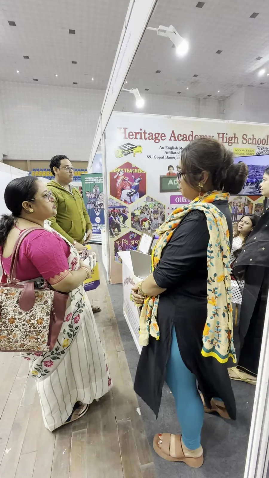 Two visitors reading material at the Heritage Academy High School stall.
